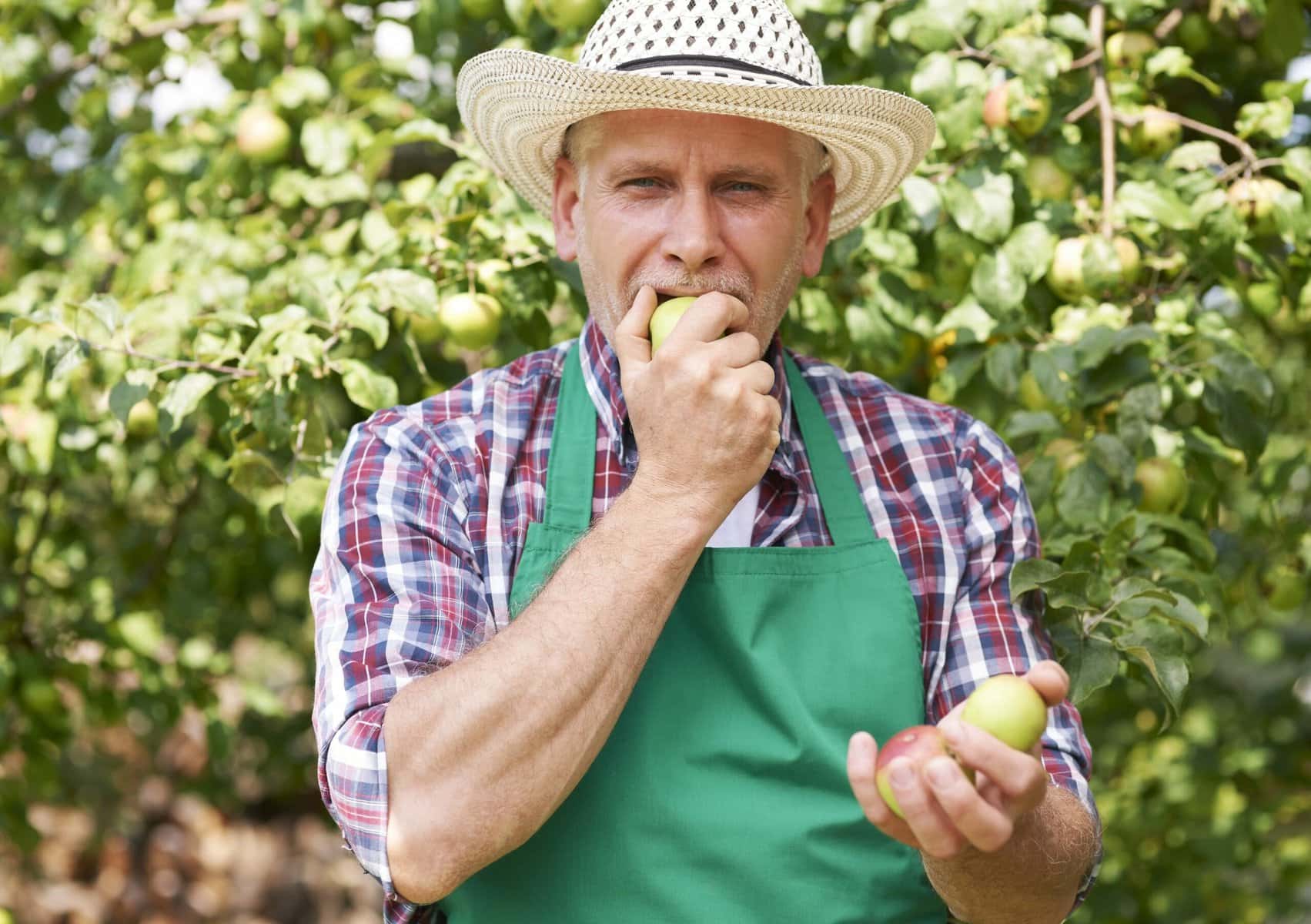 man eating apple outdoors